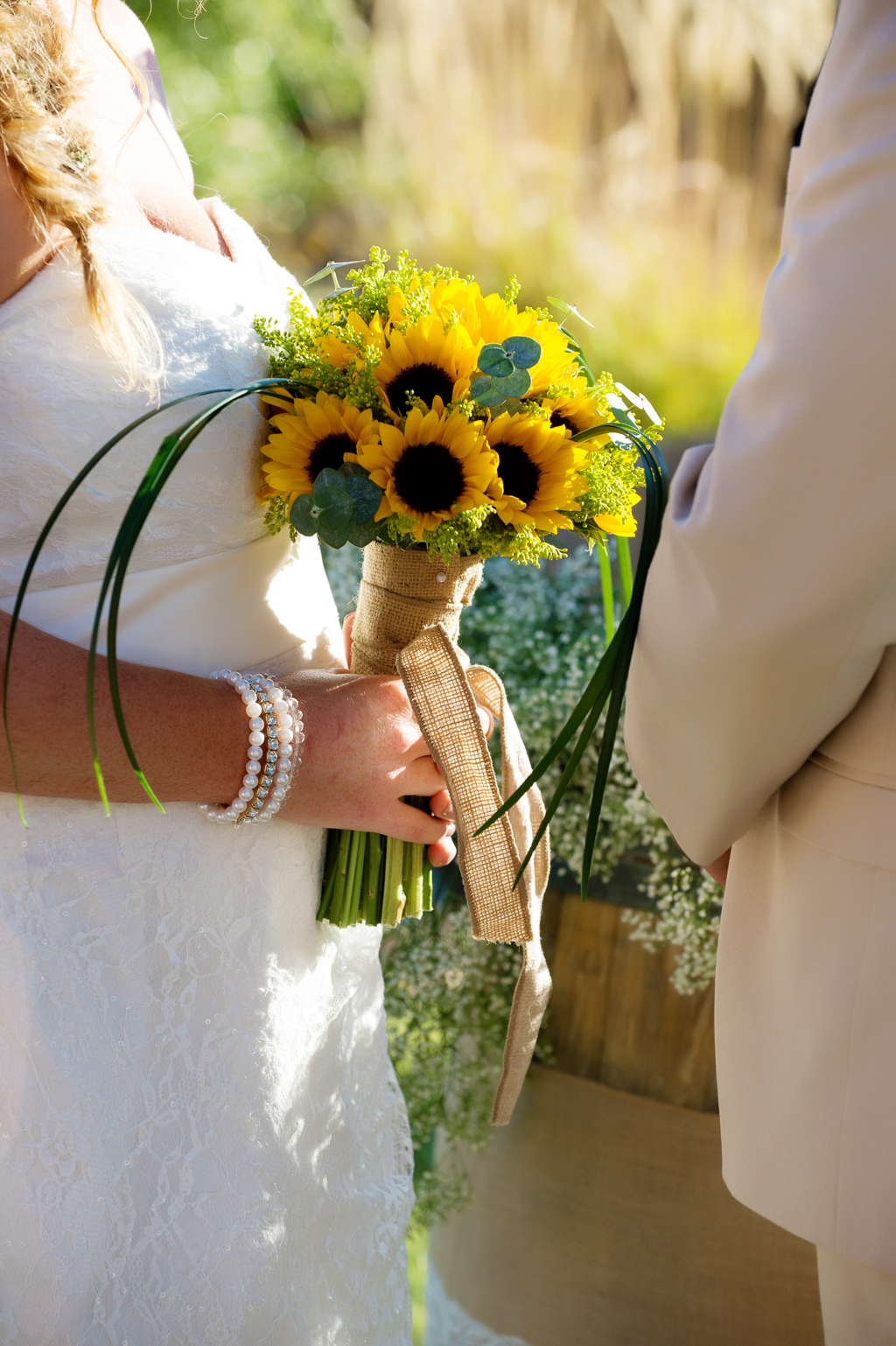 a bride holds a bouquet of sunflowers