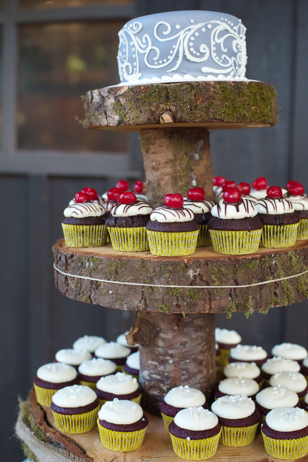 cupcakes on wooden tree stumps create a tier cake