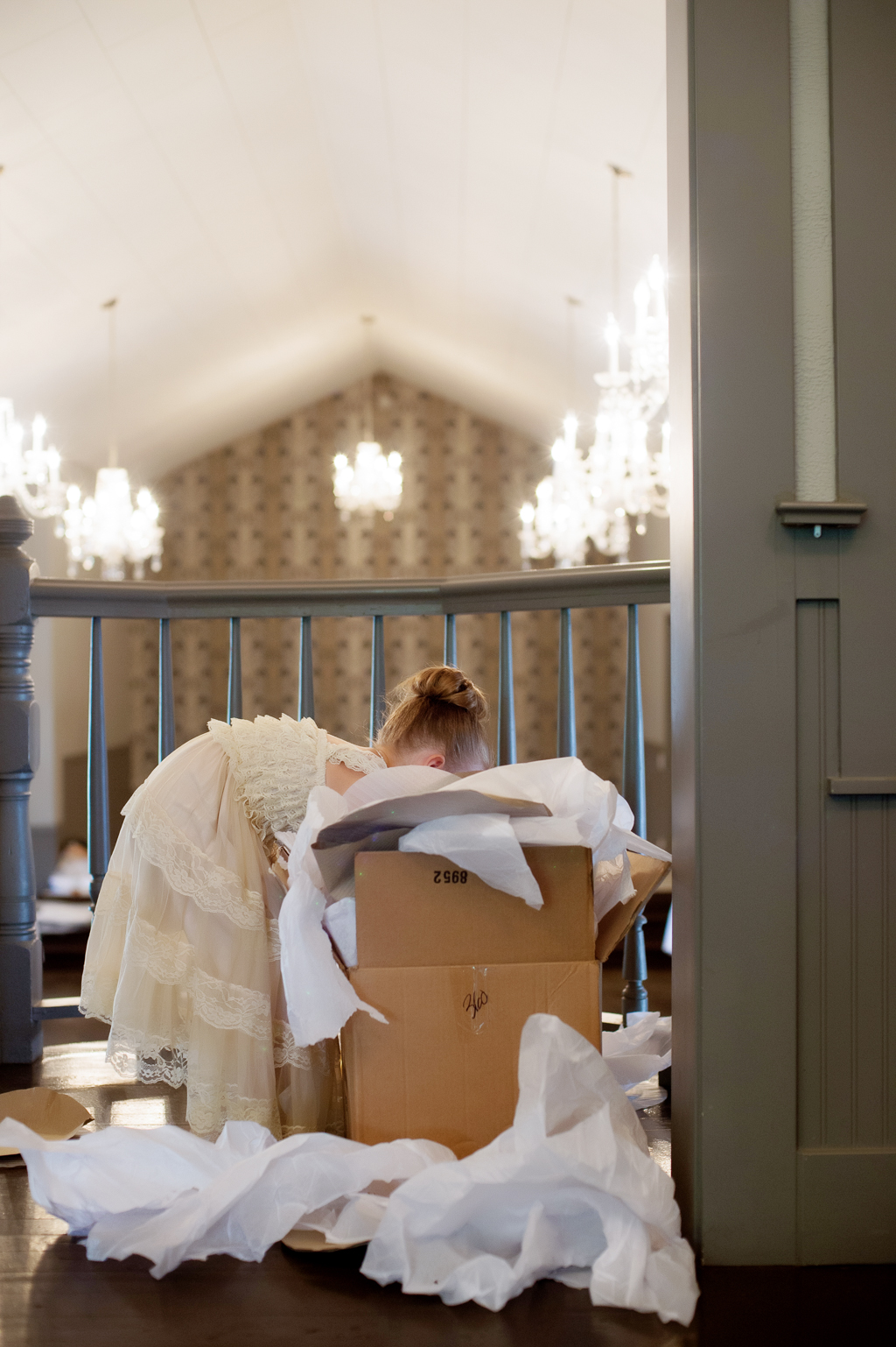 a flower girl digs through a giant box filled with tissue paper