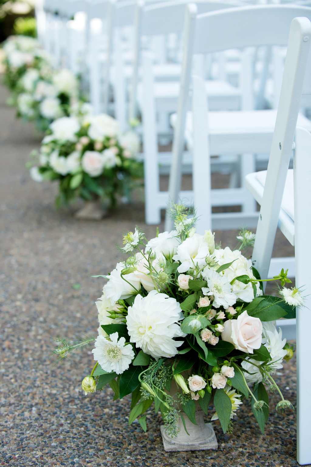 ivory and green bouquets line the ceremony aisle