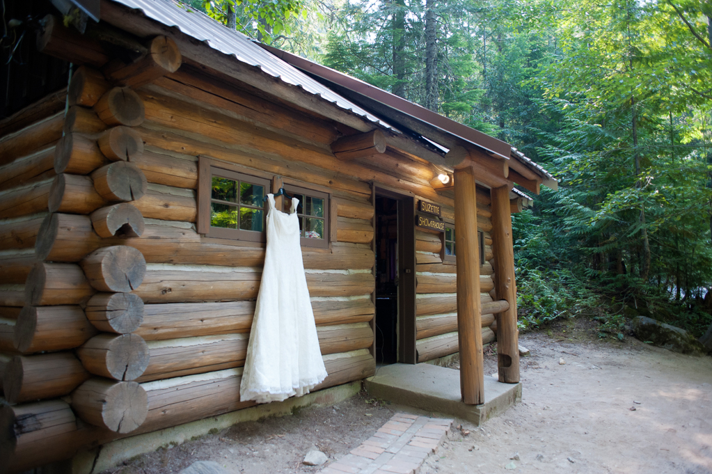a wedding dress hangs outside a summer camp cabin