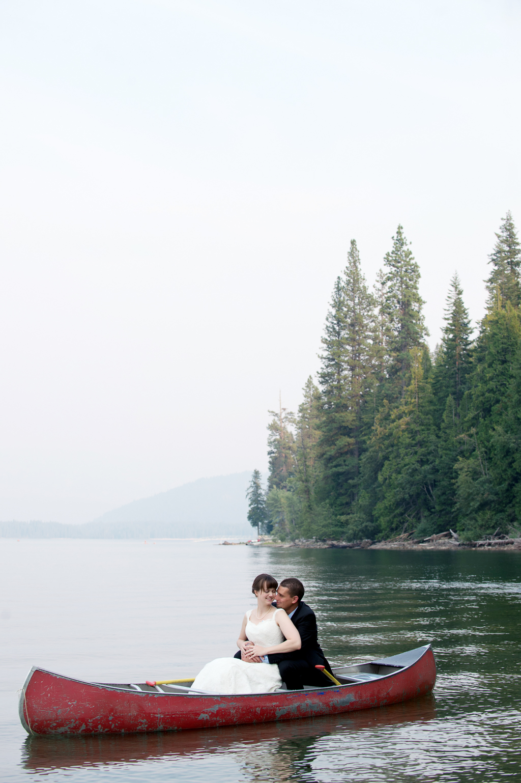 a bride and groom in a canoe embrace on lake wenatchee