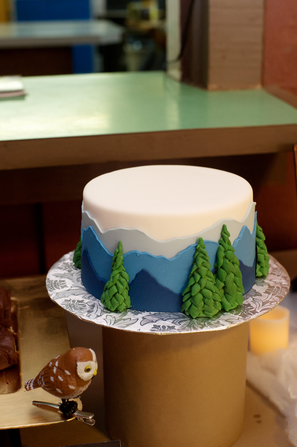 a wedding cake with a mountain scene and trees
