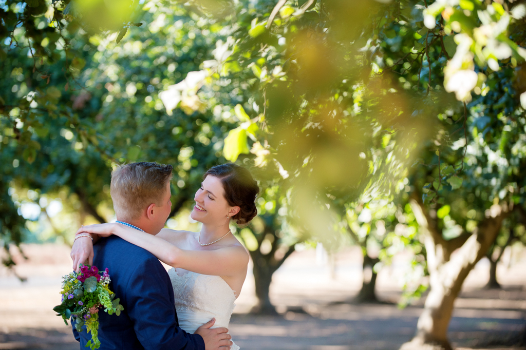 bride and groom embrace underneath hazelnut grove