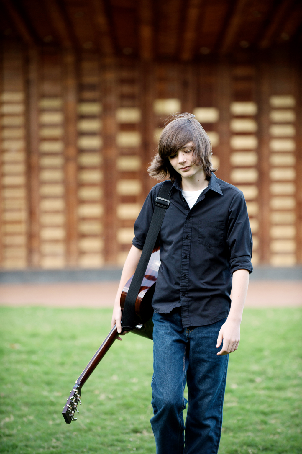 liam purcell of cane mill road walks with his guitar around his shoulder