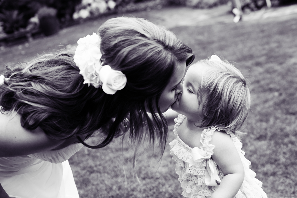 a flower girl gives the bride a kiss