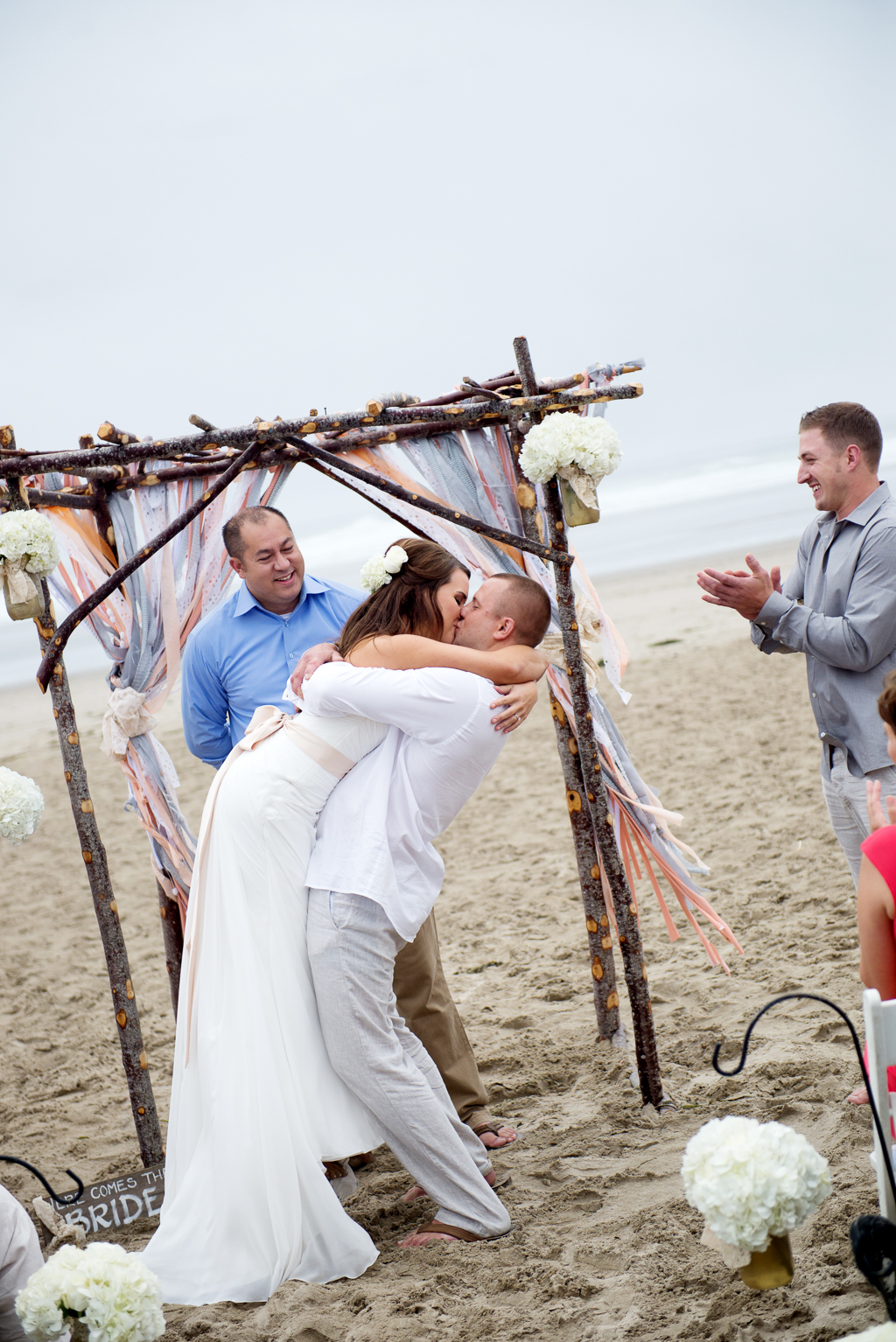a groom picks his bride off the ground during their first kiss after their wedding ceremony