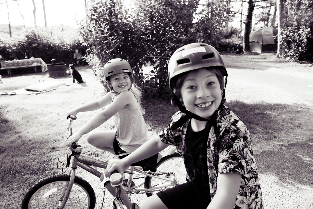 a brother and sister ride bikes at the campground at cape lookout