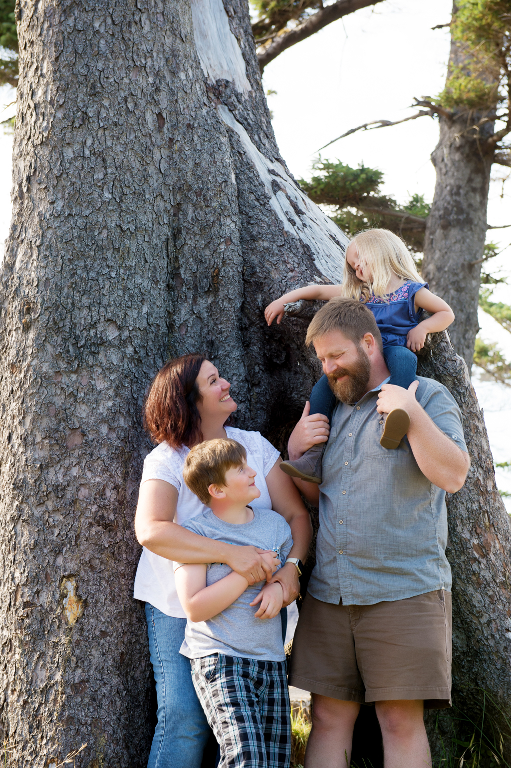 a family hugs around a big tree at cape lookout campground