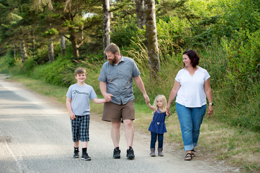 a family holds hands and walks down path at cape lookout state park campground