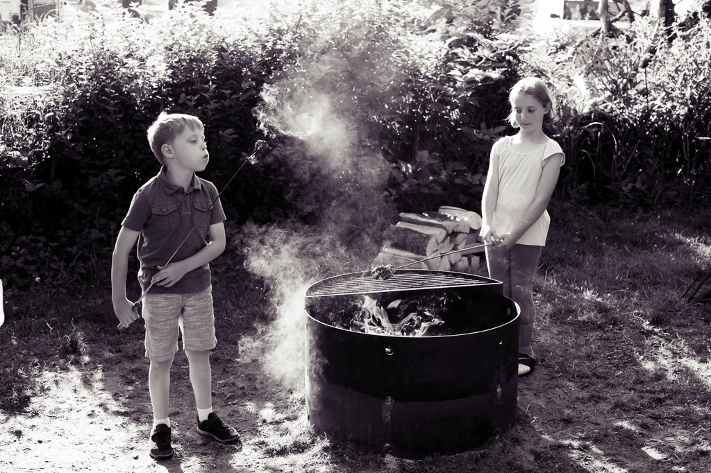 siblings burn hot dogs over a campfire at cape lookout state park campground