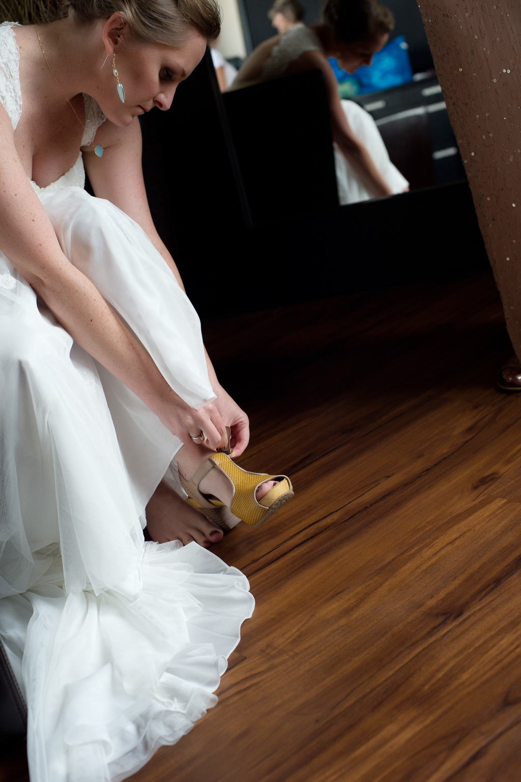 a bride puts on her vintage mustard yellow wedding shoes