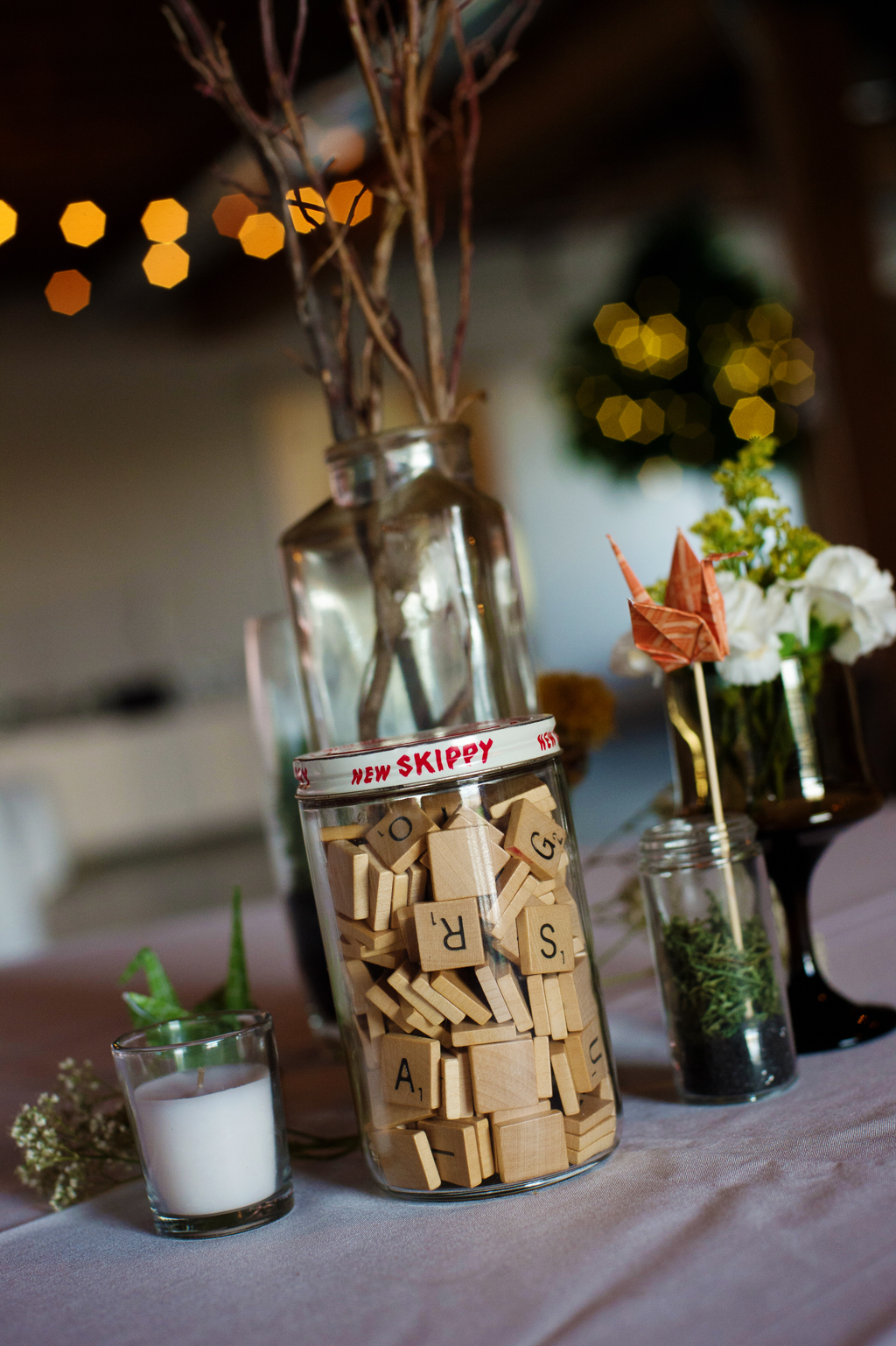 vintage scrabble pieces fill a jar on a table at a wedding reception