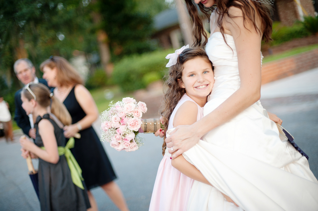 a flower girl hugs the bride