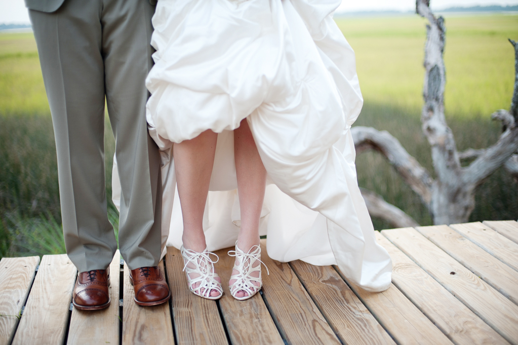 bride and groom show off their wedding shoes