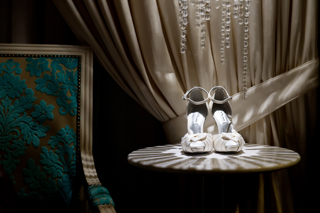white shoes on a table covered in shadows from a crystal lamp