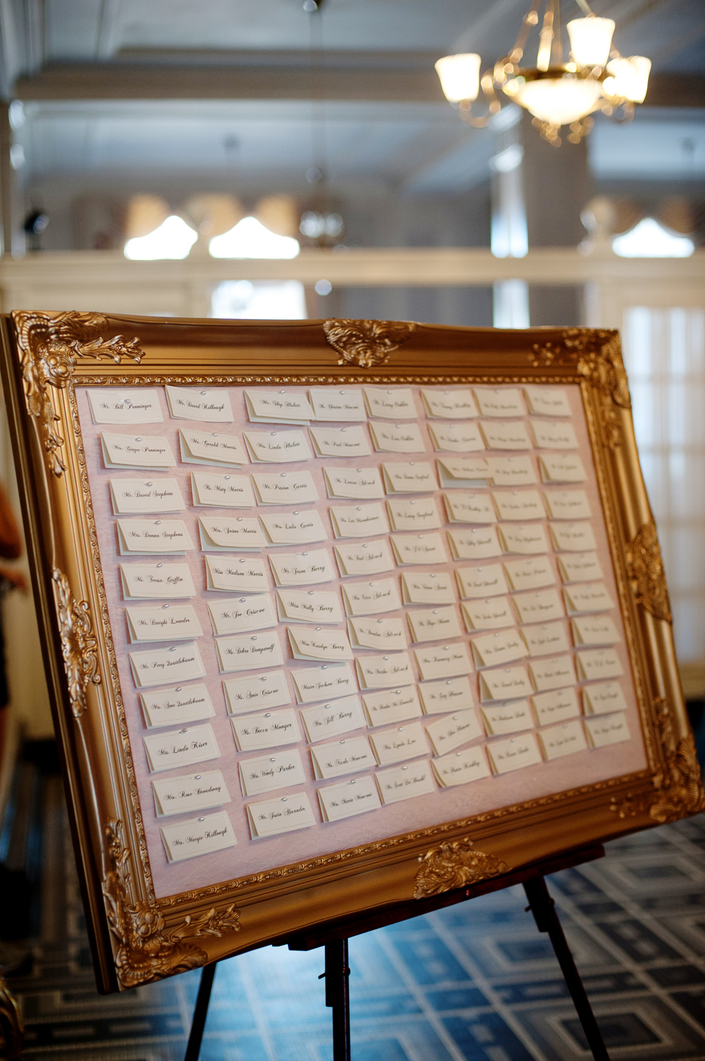a gold frame filled with wedding guest seating chart