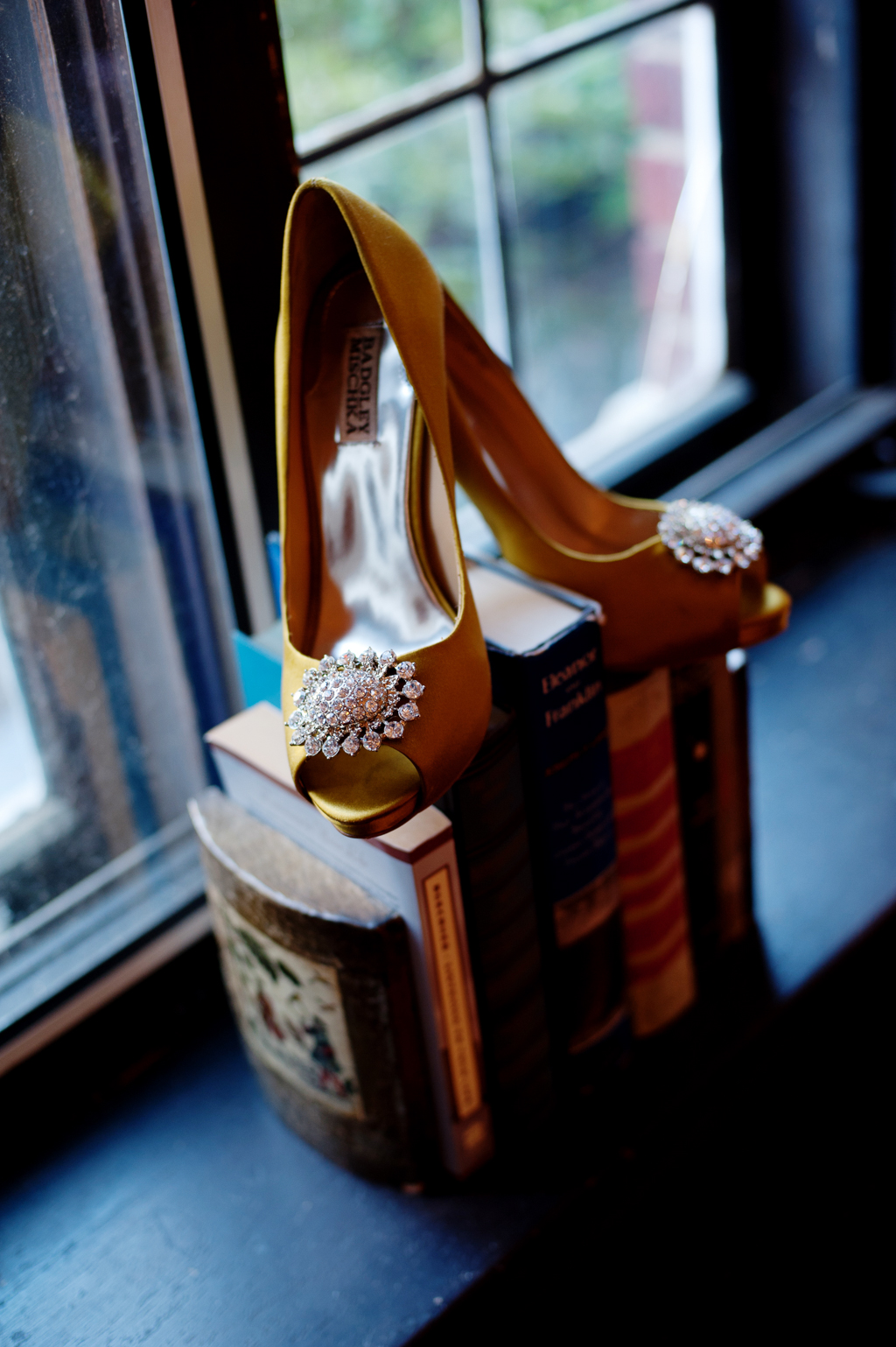mustard gold colored badgley mischka wedding heels atop a row of books