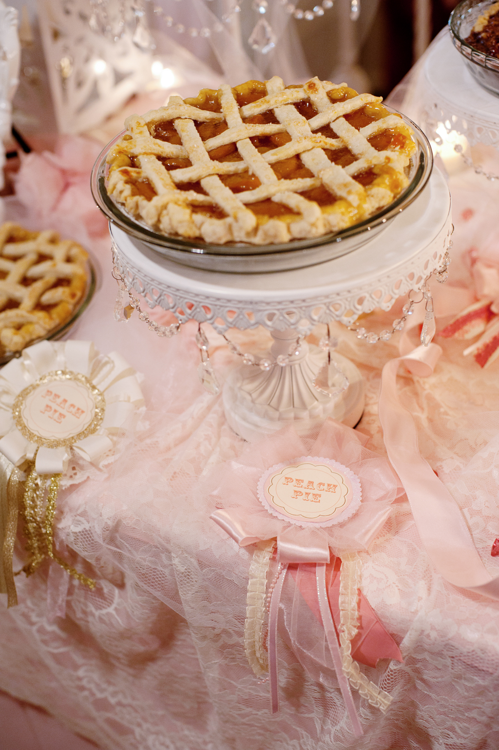 pink and gold award ribbons listing types of pies on a pink and gold covered wedding dessert table