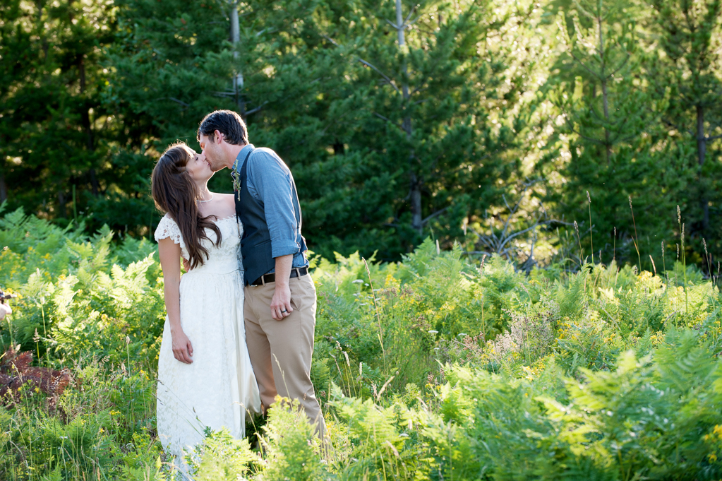 a bride and groom kiss in tall grass