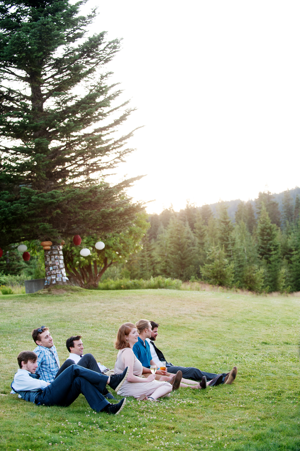 wedding guests sit in the lawn at cooper spur at sunset