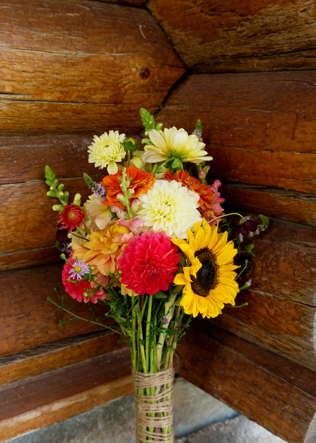 a vibrant red and yellow wildflower and sunflower bouquet