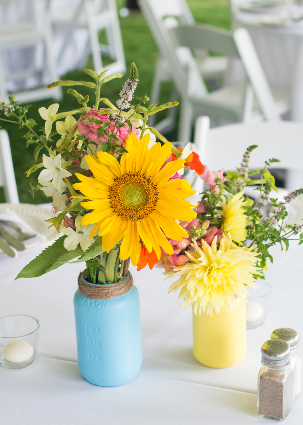 colorful wildflowers and a sunflower in a painted blue and yellow jar 
