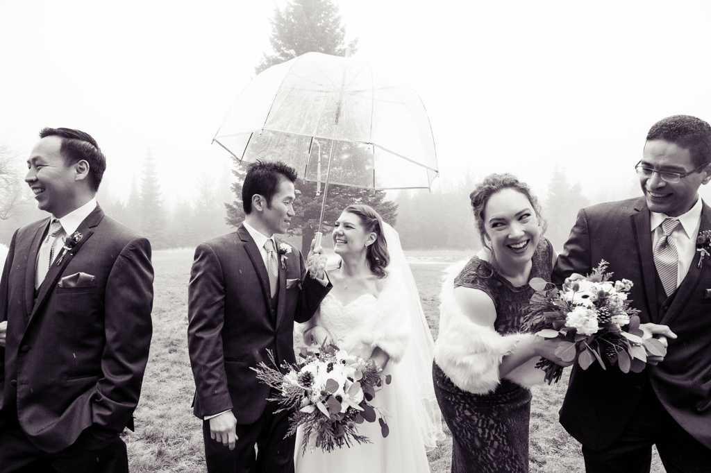 wedding party laugh in the rain on a foggy day