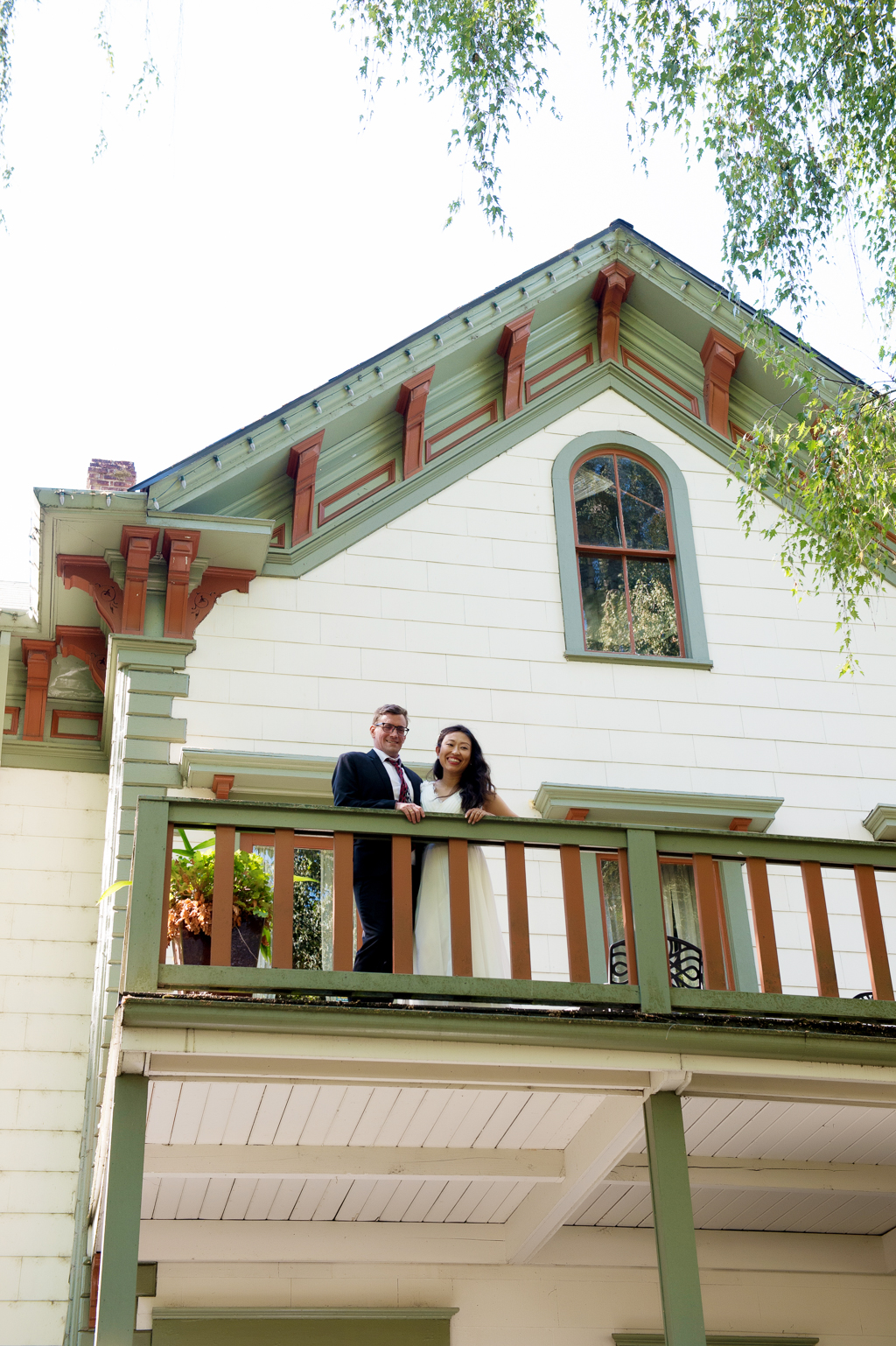 bride and groom stand on balcony at cornelius pass roadhouse