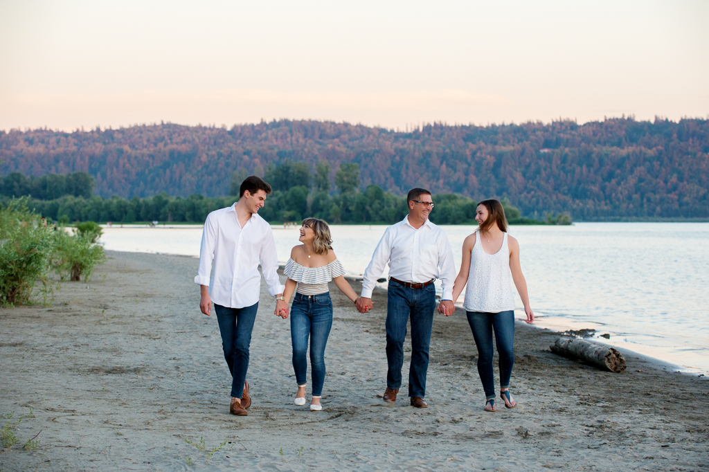 a family walks along cottonwood beach holding hands