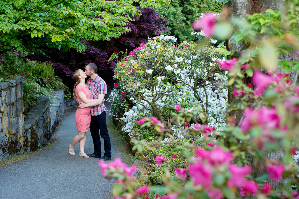 a couple kisses behind pink and white rhododendrons