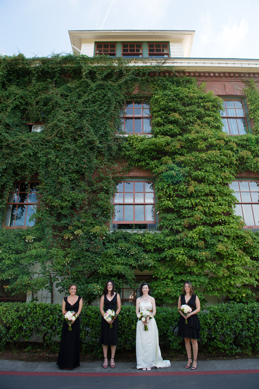bridesmaids stand under ivy covered wall at edgefield