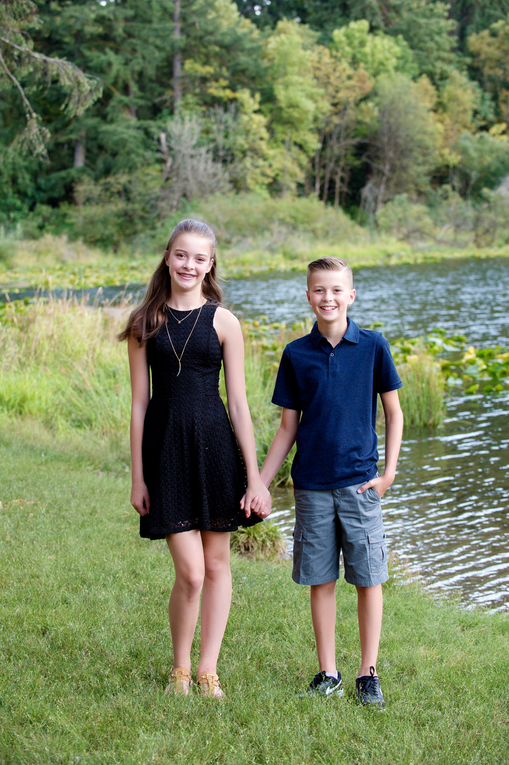 sister and brother hold hands in front of fallen leaf lake