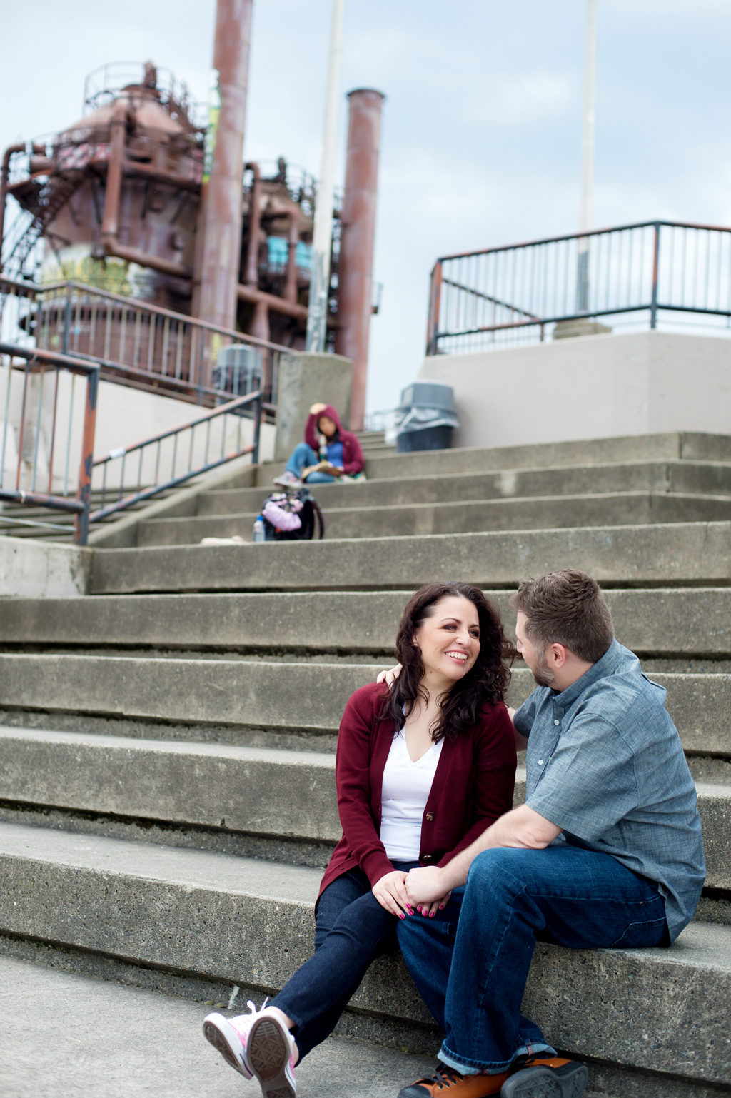 a couple sit on the stairs with gas works park in the background