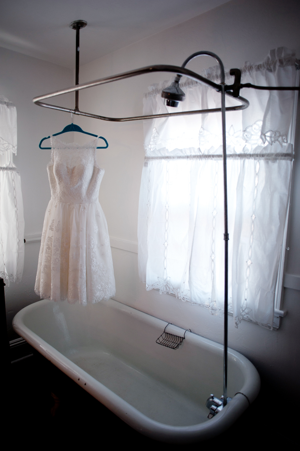 wedding dress hangs from old clawfoot bathtub