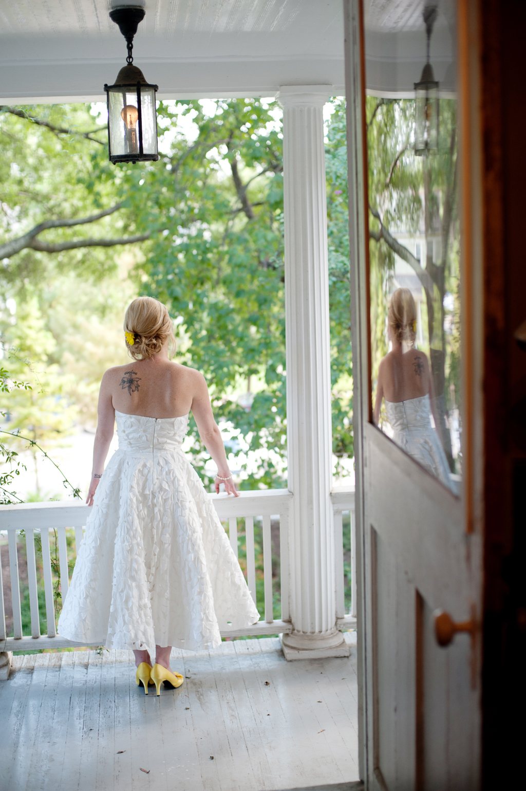 bride wears tea length wedding dress and yellow shoes on front porch