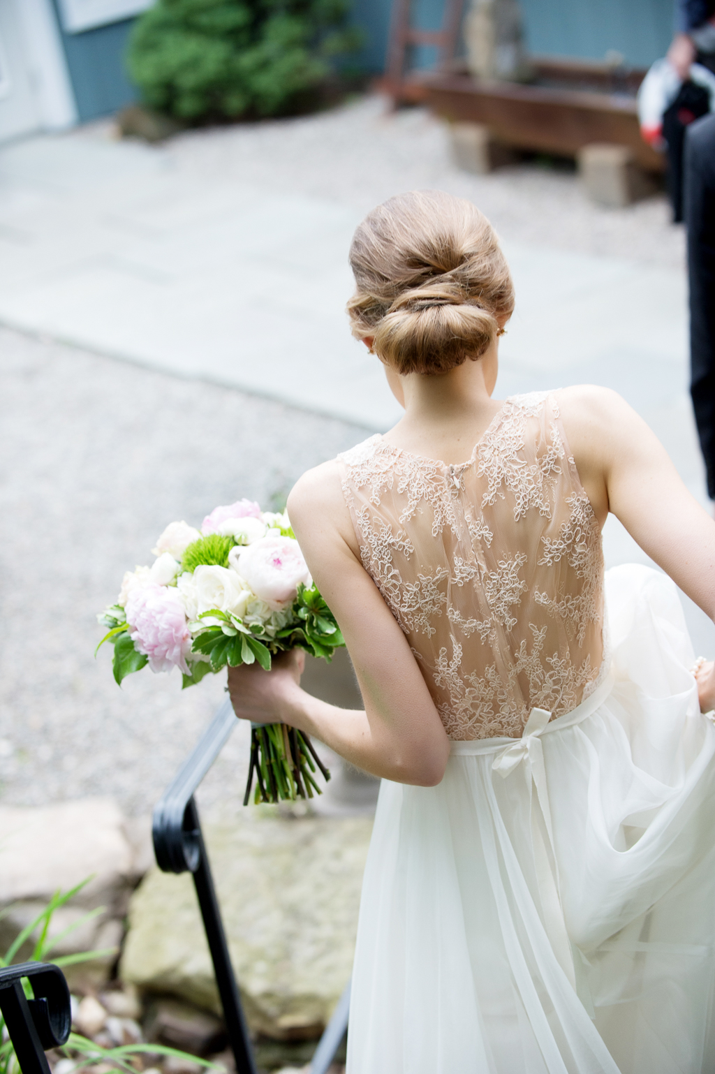 bride walks down stairs showing off her lace back wedding dress