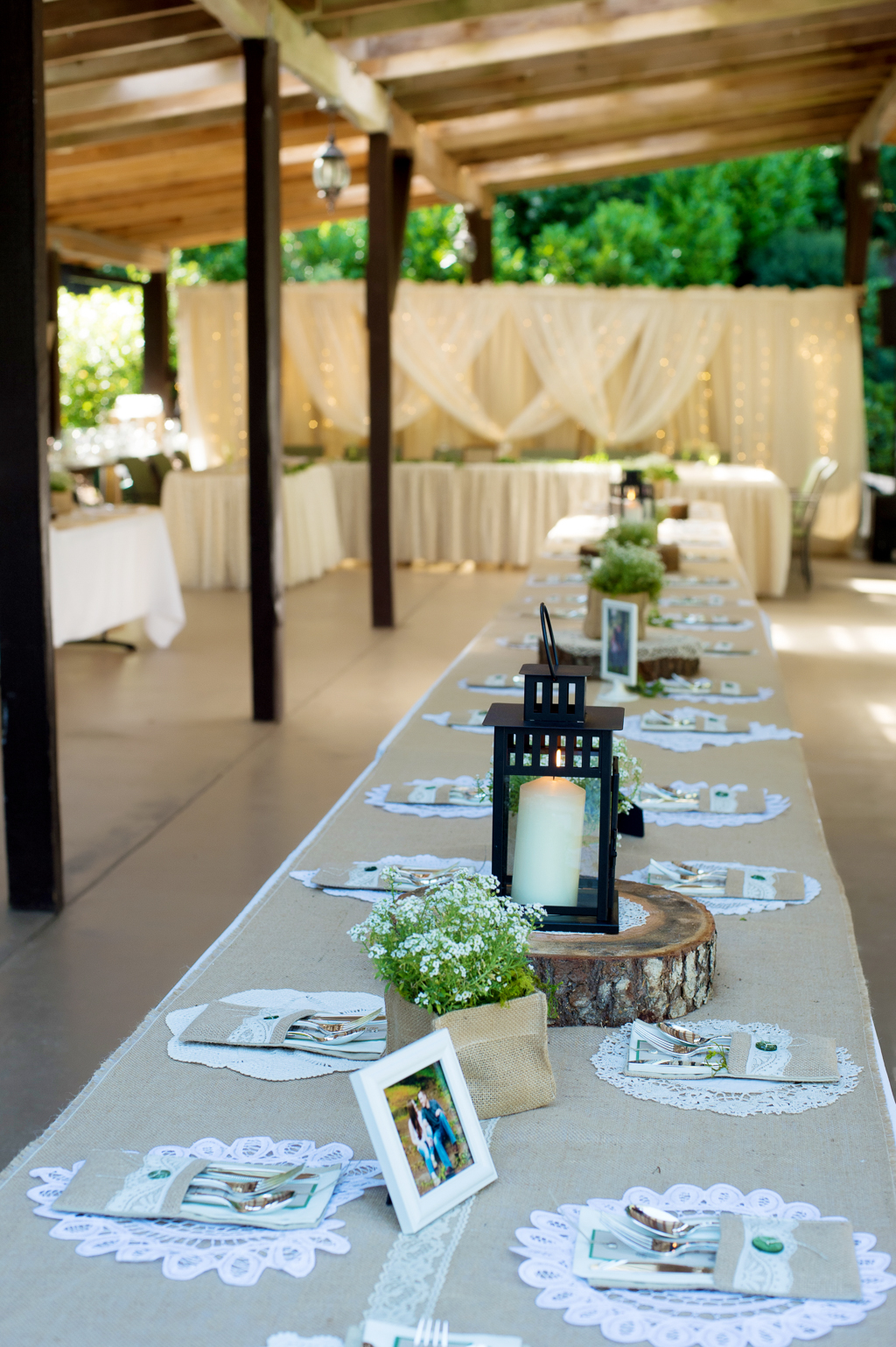 lanterns, burlap, and lace line the tables at a wedding