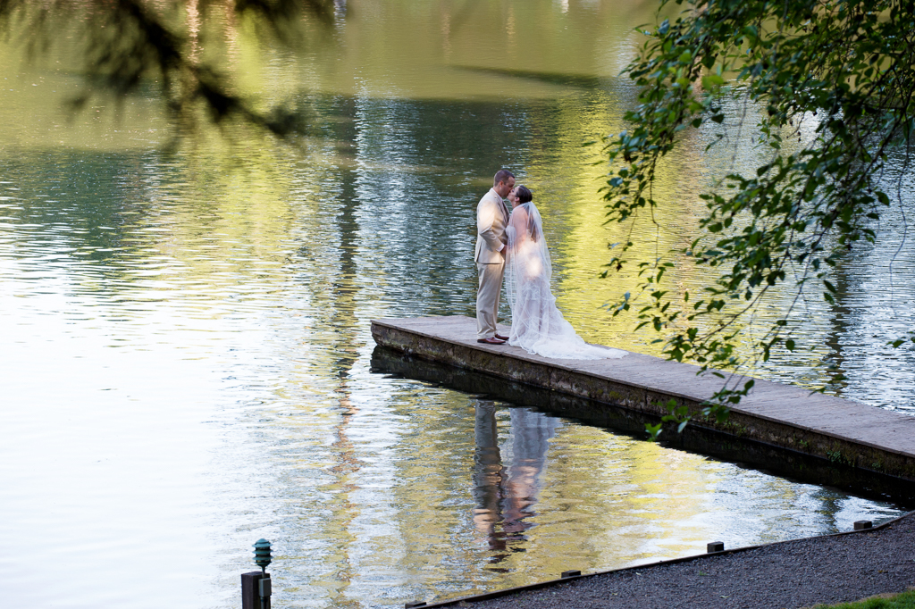 bride and groom kiss on the end of a dock at hornings hideout