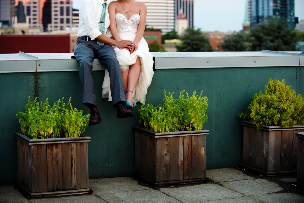 bride and groom on the rooftop overlooking portland at hotel deluxe during sunset