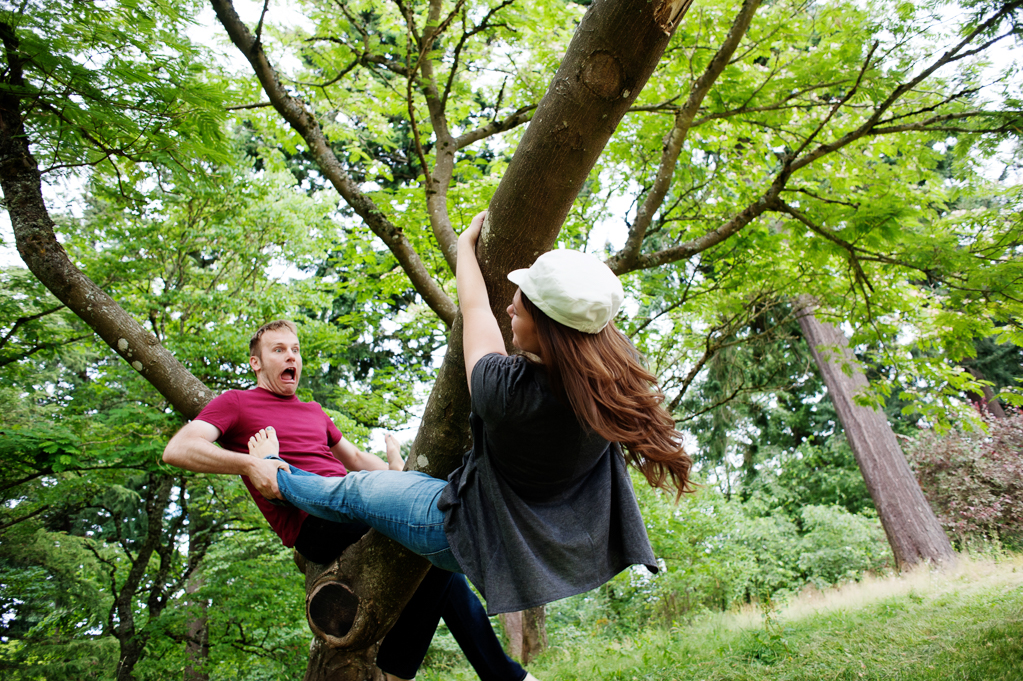 A man pretends a girl is falling out of a tree