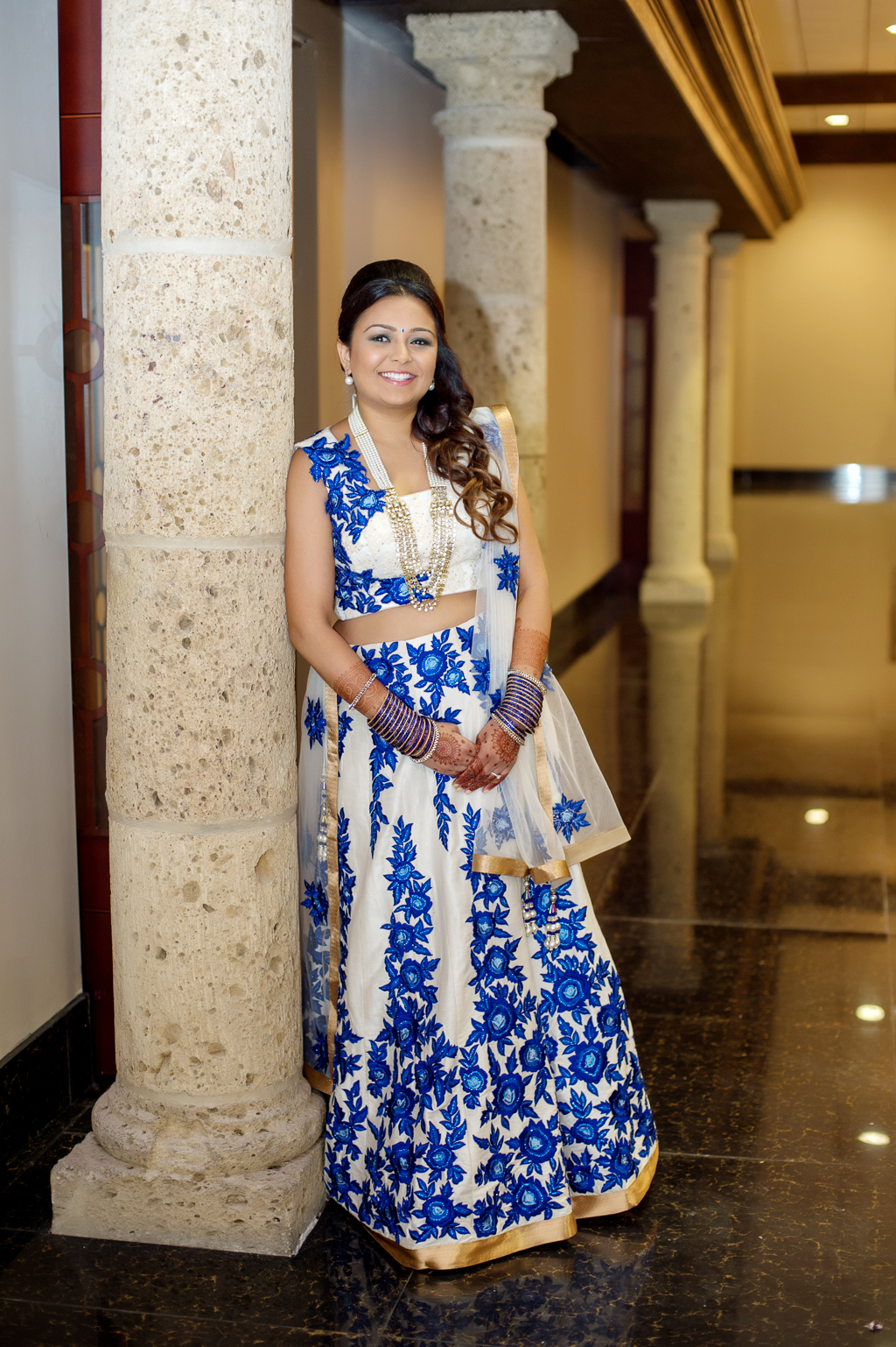 indian bride wears a blue and white dress