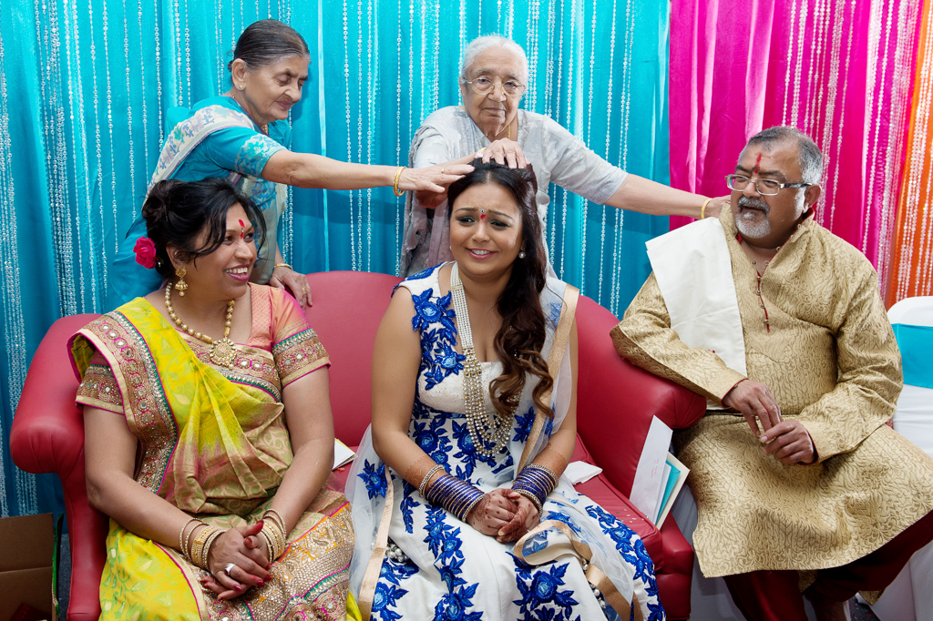 grandparents touch the bride's head during an indian wedding ceremony