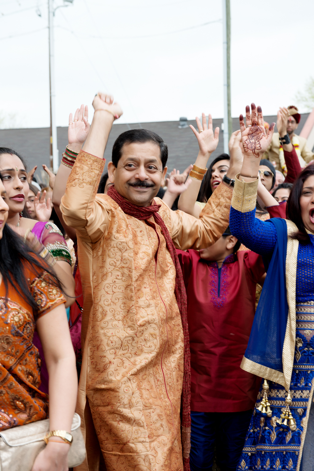 family and friends dance in celebration during the baraat