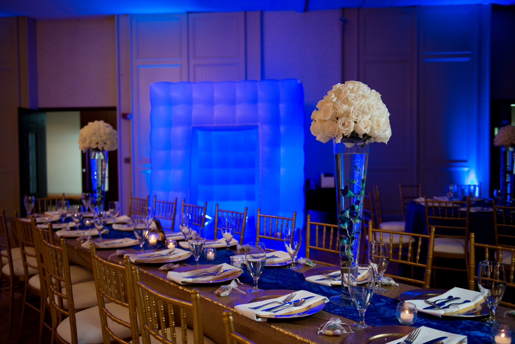 gold chairs and royal blue uplighting fill a wedding reception