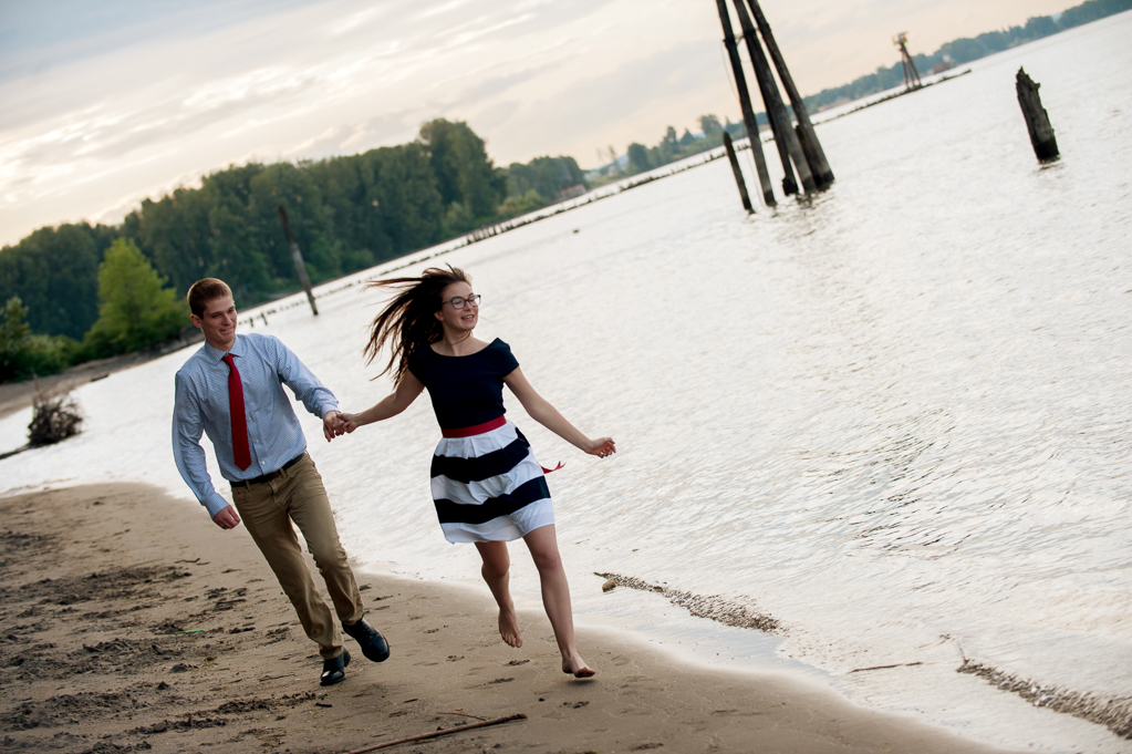 a couple wearing red white and blue run along the river at kelley point park
