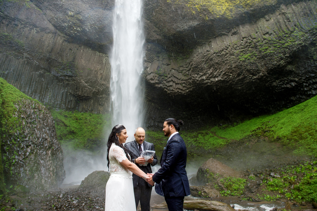 a bride and groom elope in front of latourell falls