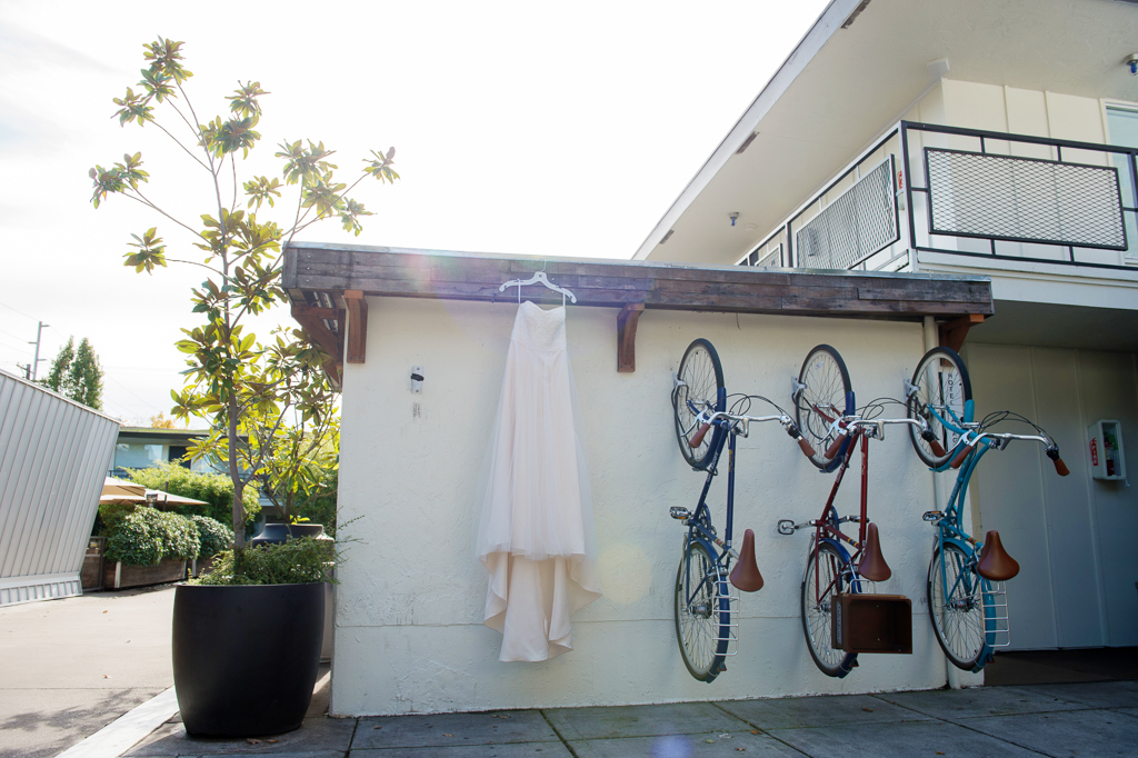 a wedding dress hangs next to bicycles on the wall at jupiter hotel