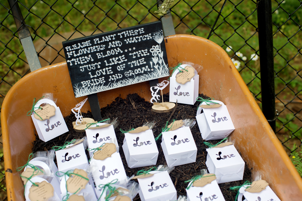 a wheel barrow is full of boxes filled with seeds as wedding guest favors