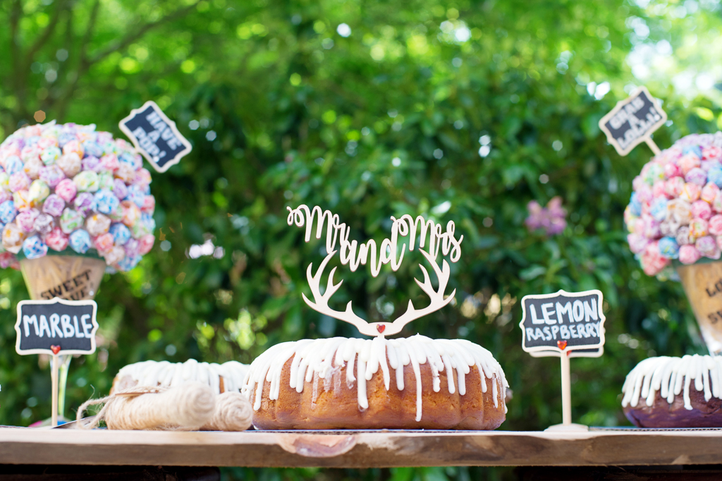 a mr and mrs antler cake topper sits atop a Nothing Bundt Cakes bundt cake with dripping white icing
